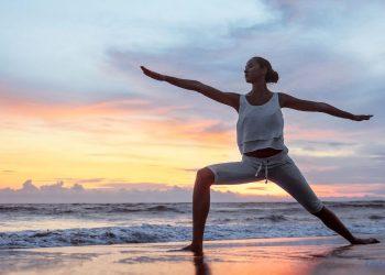 Eine Frau macht Yoga am Strand
