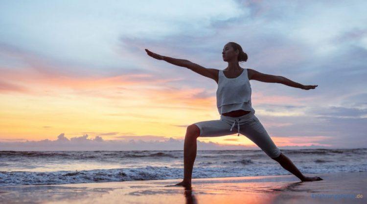 Eine Frau macht Yoga am Strand
