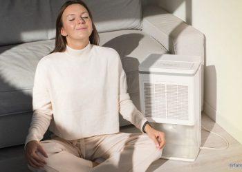 Frau sitzt neben einem Luftreiniger