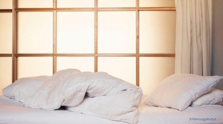 Zudecke und Kopfkissen auf einem Bett