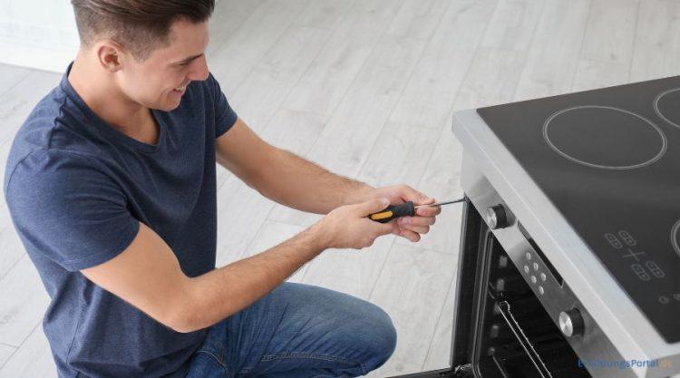 Ein Mann schraubt am Backofen