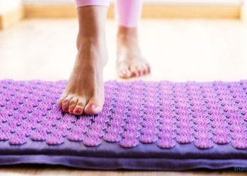 Frau steigt auf eine Akupressur Matte