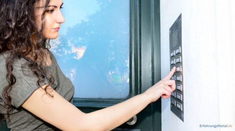 Frau betätigt eine Türklingel