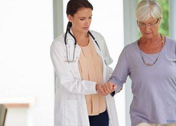 Ärztin hält älteren Dame die Hand während sie läuft