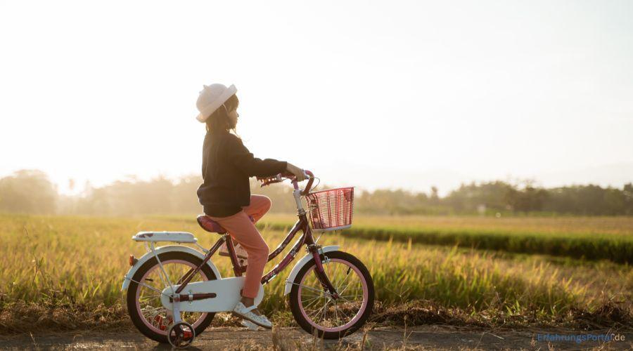 Mädchen fährt Fahrrad zwischen Feldern