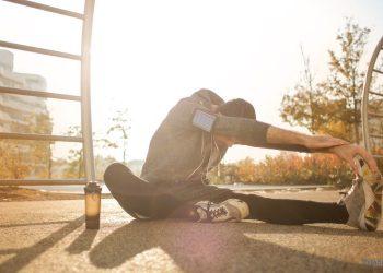 Mann macht Outdoor Dehnübungen