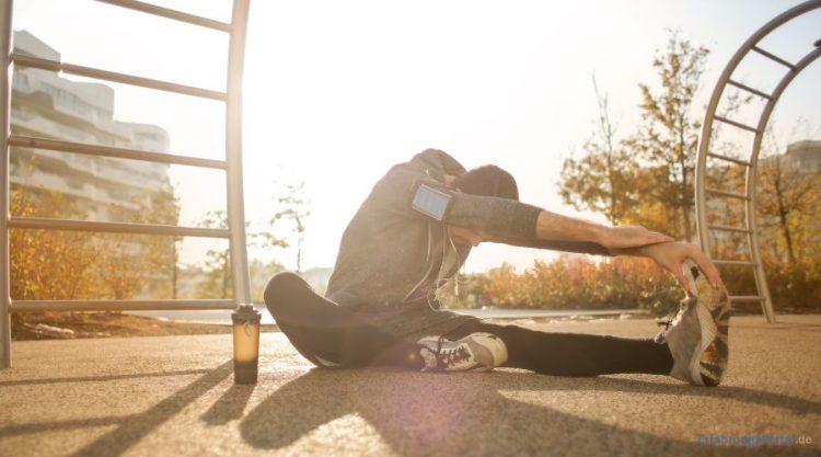Mann macht Outdoor Dehnübungen