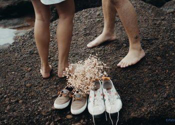 Paar hat die Schuhe am Strand ausgezogen
