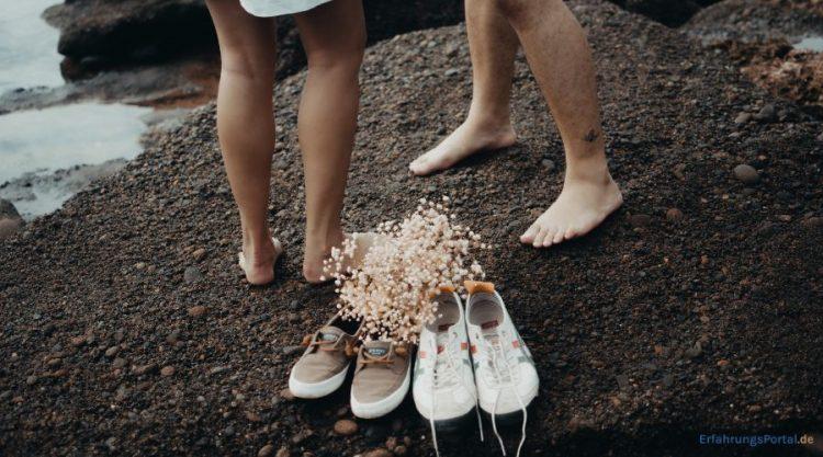 Paar hat die Schuhe am Strand ausgezogen