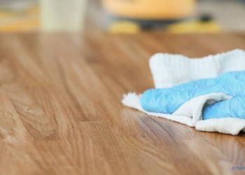 Eine Holzplatte wird mit einem Tuch sauber gewischt