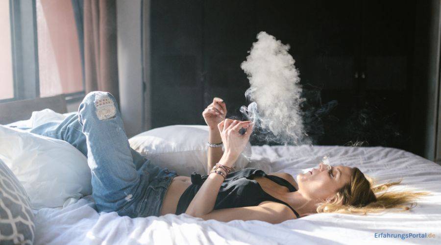 Frau raucht im Bett