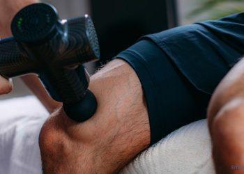 Massagepistole wird auf dem Oberschenkel angewendet