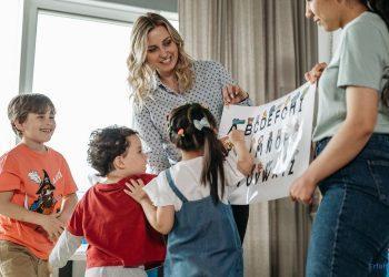 Erzieherinnen zeigen den Kindern ein Lernposter