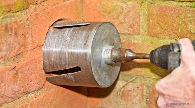 Es wird ein kreisrundes Loch in eine Wand gebohrt