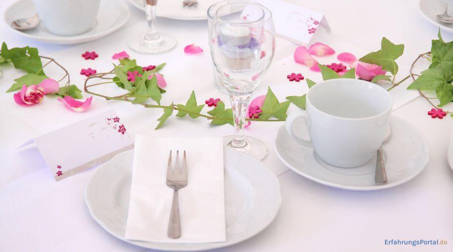gedeckter Tisch mit Blumenblättern und Efeu