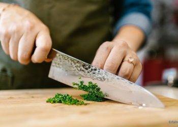 Es wird mit einem scharfen Messer Schnittlauch geschnitten