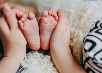 Frau hält Babyfüße in den Händen