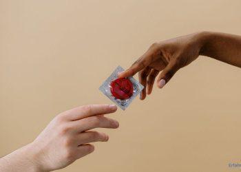 Frau reicht einem Mann ein Kondom