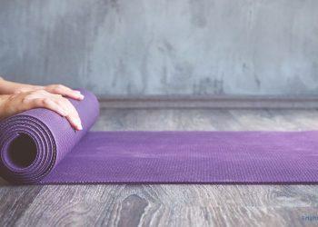 Lila Yogamatte wird eingerollt