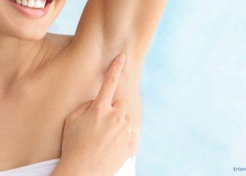 Frau streicht sich mit einem Finger über die Achseln