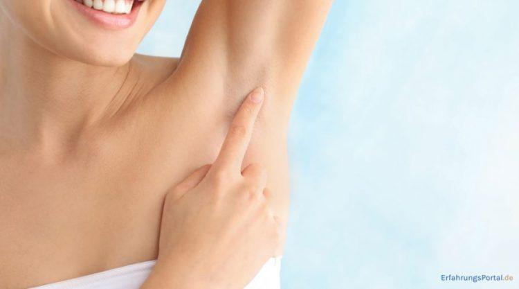 Frau streicht sich mit einem Finger über die Achseln