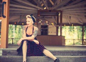 Frau mit Rockabilly Stil sitzt auf einer Treppe