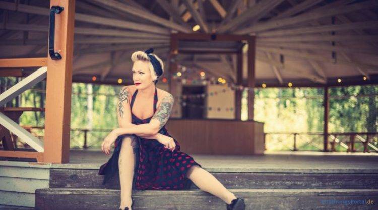 Frau mit Rockabilly Stil sitzt auf einer Treppe