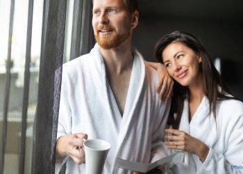 Paar im Bademantel am Fenster