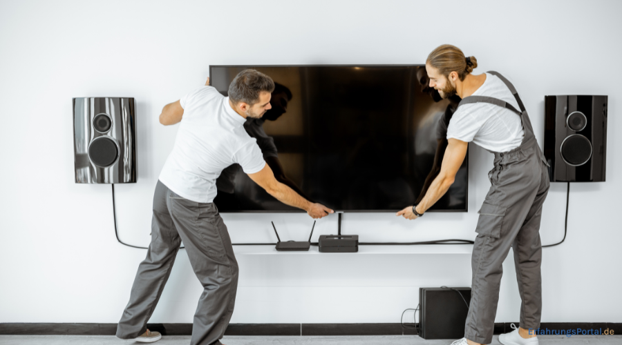 Männer montieren einen TV an einen TV Lift