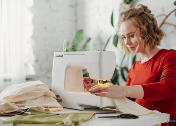 Eine Frau sitzt vor der Nähmaschine und näht etwas