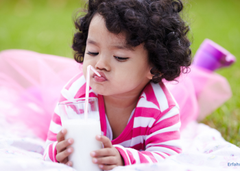 Kleines Kind trinkt ein Glas Milch