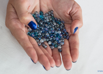 Frau hält Glasperlen in der Hand