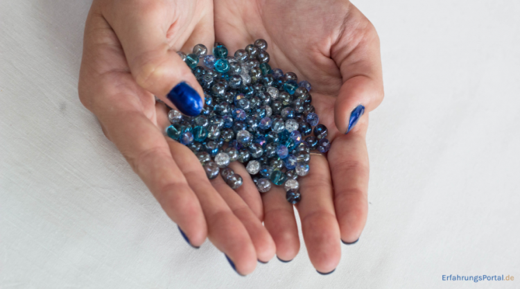 Frau hält Glasperlen in der Hand