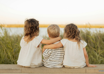 Kinder sitzen am Wasser